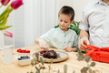 Dad and son decorate a heart-shaped cake with fresh berries and prepare a gift. Mother's Day - PhotoDune Item for Sale