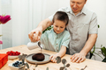 Dad and son are preparing a congratulatory cake, pouring chocolate icing on the cake - PhotoDune Item for Sale