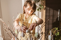 A teenage girl decorates the branches of the house with Easter eggs. Easter decoration  - PhotoDune Item for Sale