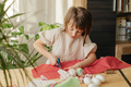 Making Easter eggs in the shape of a hare from textile. The girl prepares the fabric, cuts it with s - PhotoDune Item for Sale