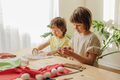 A boy and a girl, sibling are crafting Easter eggs from cloth in the shape of a bunny.  - PhotoDune Item for Sale
