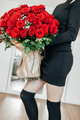 Happy young woman with a huge bouquet of red roses. Flowers for any holiday. Sending flowers  - PhotoDune Item for Sale