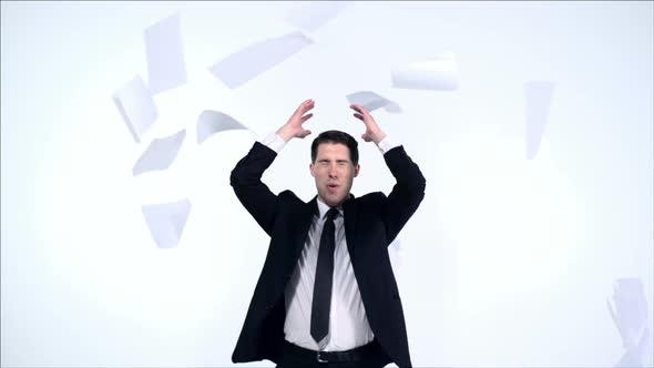 Young business man trying to catch pile of papers, Slow Motion