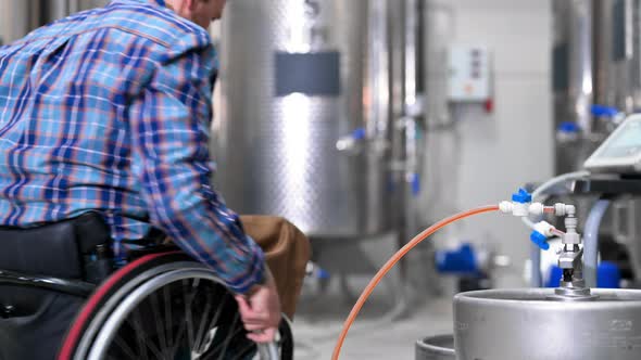Man in Wheel Chair Working in Brewery Factory