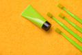 Green toothbrushes with paste tube on yellow towel. Significance of maintaining good dental hygiene. - PhotoDune Item for Sale