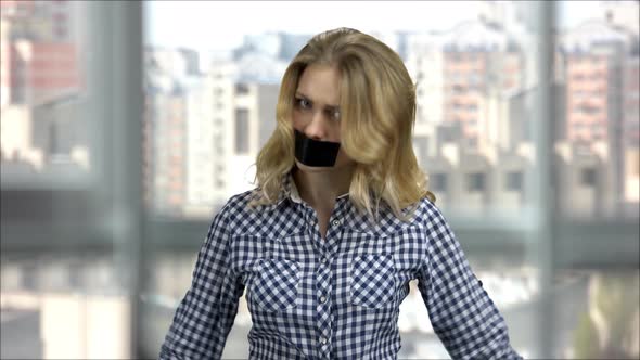 Young Irritated Woman with Taped Mouth
