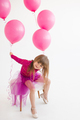 Funny kid girl celebrating birthday with balloons in room over white - PhotoDune Item for Sale