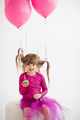 Funny kid girl celebrating birthday with balloons and cake in room over white - PhotoDune Item for Sale