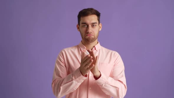 Studio Portrait of Satisfied Young Man Clapping in Hands Applauding and Looking at Camera on Pink