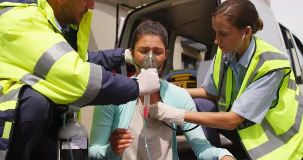 Patient receiving oxygen mask from ambulance team
