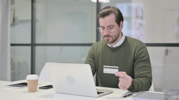 Young Businessman Making Successful Online Payment on Laptop