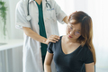 Female doctor chiropractor or osteopath setting woman neck joints with hands during visit and treatm - PhotoDune Item for Sale
