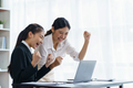 Happy two Asian business women raising their hand to congratulate their achievement and rejoice - PhotoDune Item for Sale