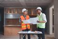 Two Asian male engineers are inspecting a job site and looking at drawings, consulting and debugging - PhotoDune Item for Sale