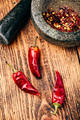 Dried red chili peppers on wooden surface with mortar and pestle - PhotoDune Item for Sale