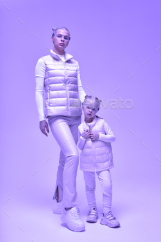 Wearable technology concept. Young woman with her little daughter in a white high-tech clothes