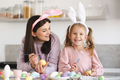Smiling woman making Easter decorations with kid girl together - PhotoDune Item for Sale