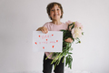 Cheerful happy child with Peonys bouquet and a card for mom in Ukrainian. - PhotoDune Item for Sale