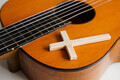 Acoustic guitar with wooden cross on the table close up. Christian music. - PhotoDune Item for Sale