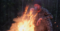 Man with cup of tea the fire in the forest. Human looks at the bonfire and drinks tea on the nature  - PhotoDune Item for Sale
