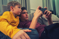 Boys spending time in a social network using mobile phones. Children with smartphones at home.  - PhotoDune Item for Sale