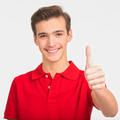 Portrait of happy young man showing thumbs up gesture, isolated over white background.  - PhotoDune Item for Sale
