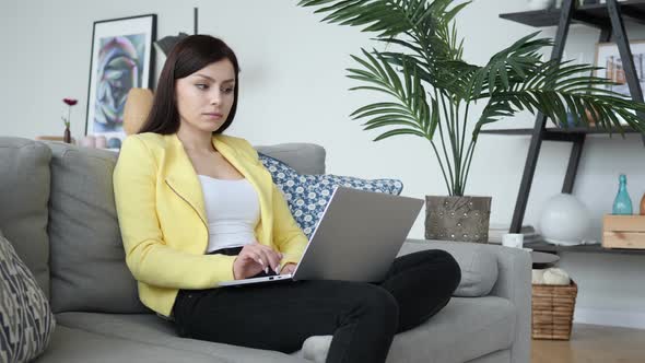 Woman in Shock Looking at Camera While Working on Laptop