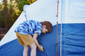 cute little caucasian boy helping to put up a tent. Family camping concept - PhotoDune Item for Sale