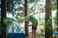 caucasian man wearing a hat putting up a tent. Family camping concept - PhotoDune Item for Sale