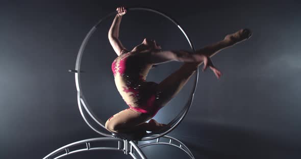 Gymnastics Performance in the Studio in Low Lighting By a Young Woman Hoop