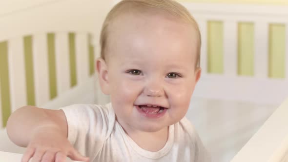 Playful Baby In White Crib Dancing Singing And Smiling alt