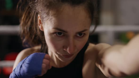 Female Boxer Performing Active Punching in Bandages Close Up
