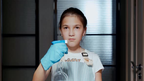 A Young Girl with a Hand Sprayer in Her Hands