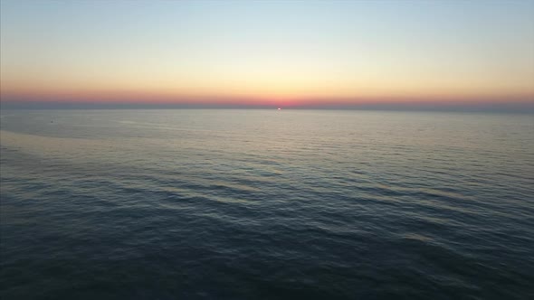 Flying backwards away from the sunset across Lake Michigan