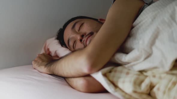 Sleeping Asian man sweet dreaming in the bedroom at home.