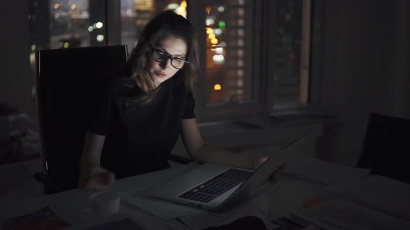 Business Woman with Glasses Working on a Computer in the Late Evening. Portrait of a Young