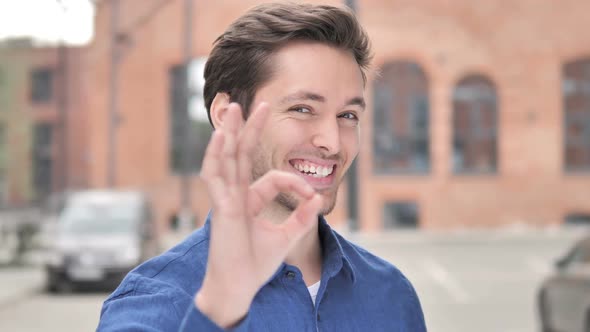 Okay Sign By Satisfied Young Man Standing Outdoor