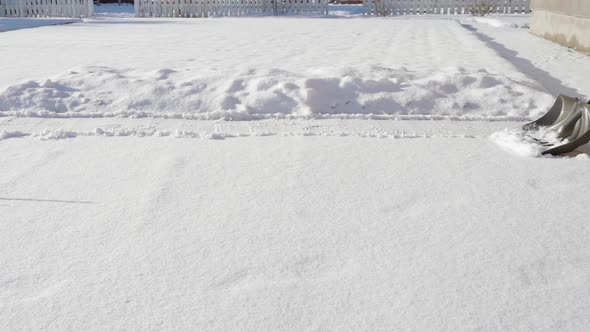 Shoveling Snow with a Shovel in Sunny Weather