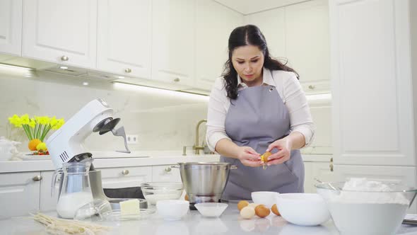 A Woman Breaks an Egg and Separates Yolks From Proteins