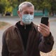Senior Man Wearing a Medicinal Mask Talking on Video Chat with Their Children. - VideoHive Item for Sale