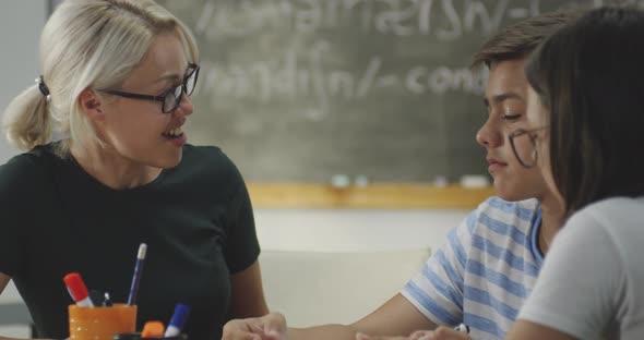 Teacher Explaining To Pupils in a Classroom