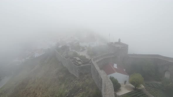 A drone flies through the mist above Marvão Castle and the nearby town.