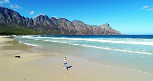 Aerial of woman walking on beautiful beach 