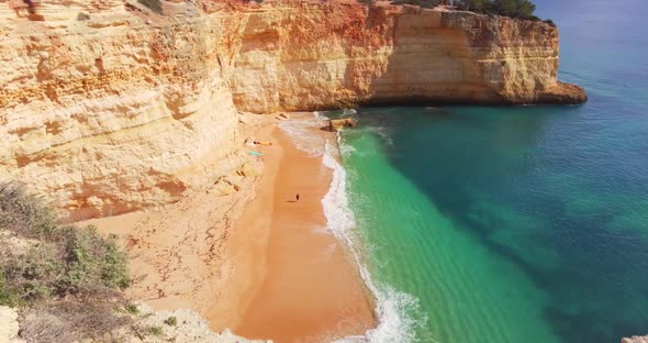 One Person Walking Alone on Golden Beach