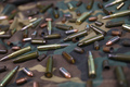 Many rifle bullets and cartridges on dark camouflage background - PhotoDune Item for Sale