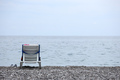 Chair on bank of pebbles with the sea and beach - PhotoDune Item for Sale