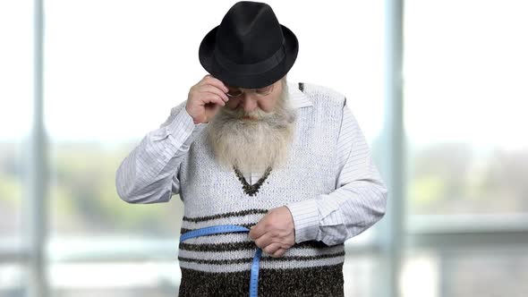 Elderly Man Measuring Hos Waist with a Blue Waistline