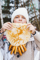 Russian national festival Maslenitsa, shrovetide. Little cute beautiful girls in headscarf eat big  - PhotoDune Item for Sale