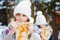 Russian national festival Maslenitsa, shrovetide. Little cute beautiful girls in headscarf eat big  - PhotoDune Item for Sale