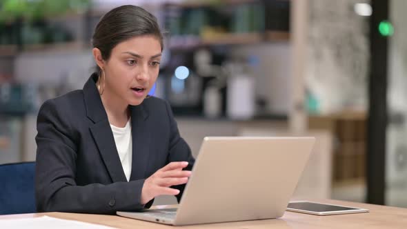 Excited Young Indian Businesswoman Celebrating Success on Laptop in Cafe